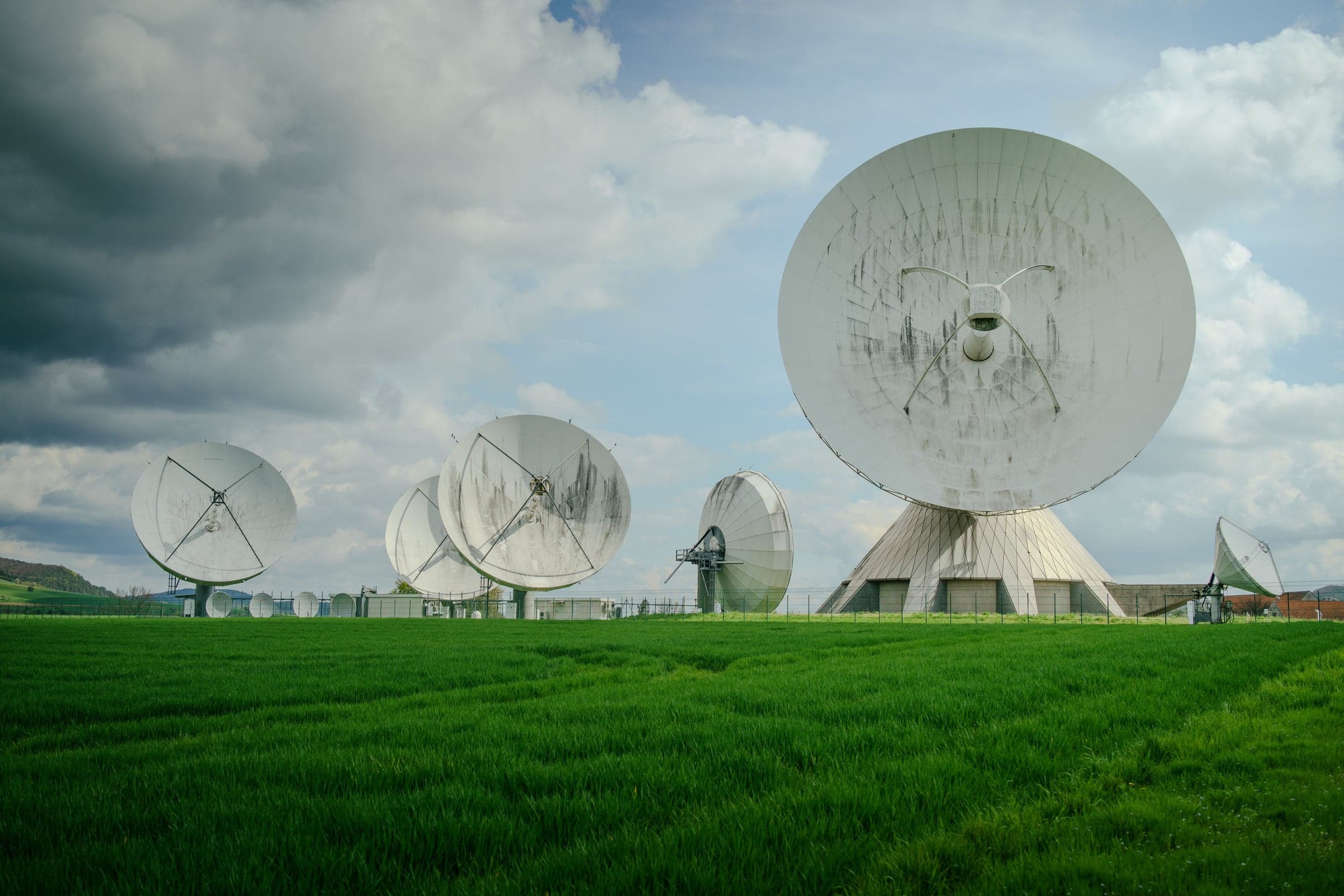 Parabolantennen einer Bodenstation für Satellitenkommunikation auf einer Wiese
