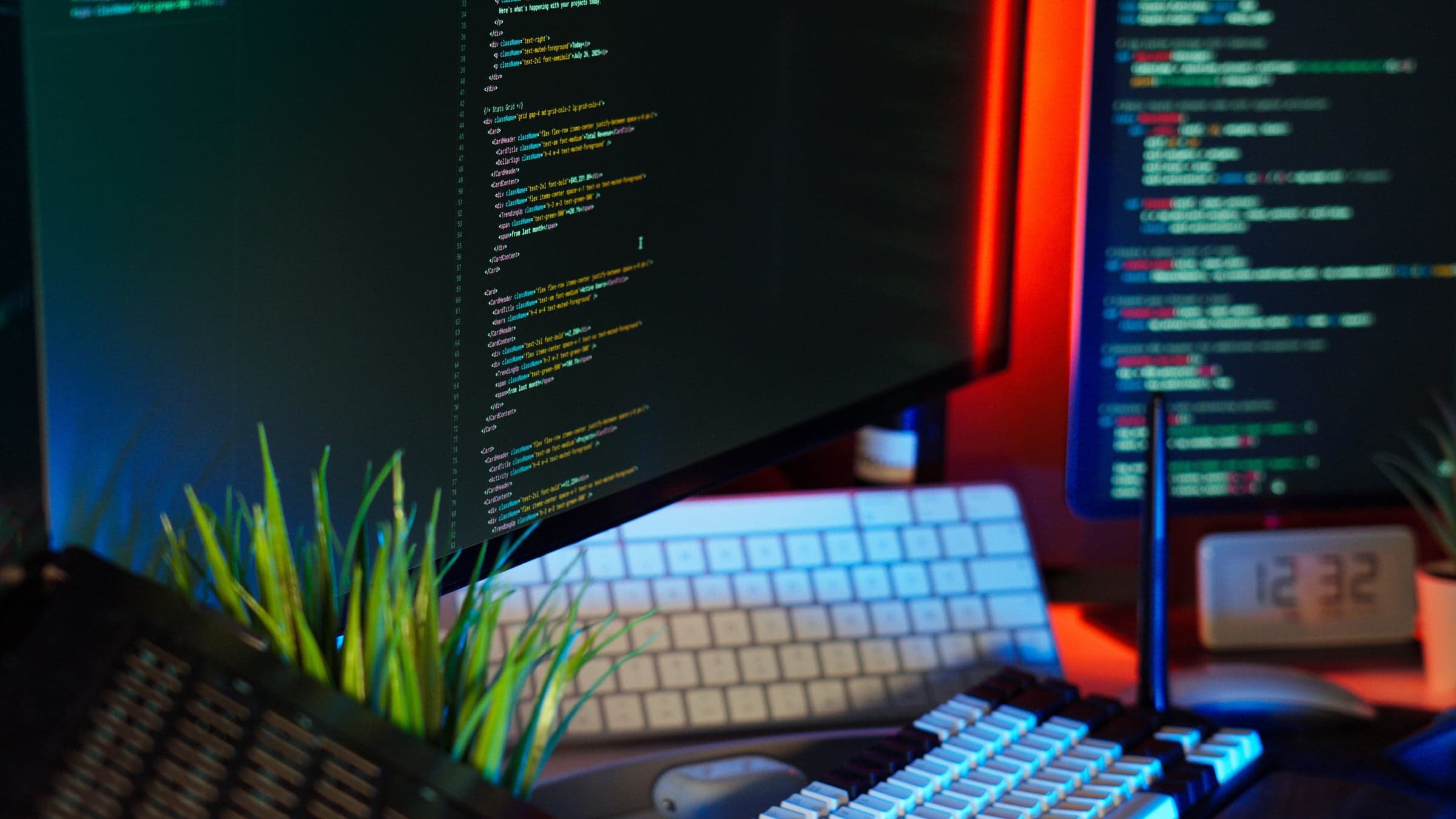 Entwickler-Arbeitsplatz bei Nacht, Code als unscharfes Glühen auf zwei Monitoren